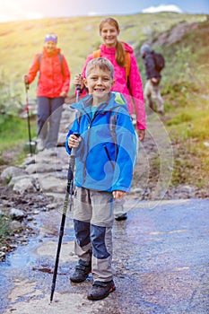 Cute boy with hiking equipment in the mountains