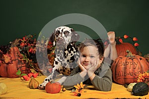 Cute boy and his dog in Halloween decoration