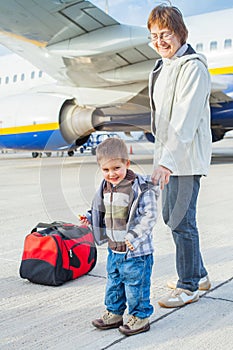 Cute boy and his grandmother prepared to fly