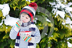 Cute boy holding big cup and hot chocolate drink and marshmallo