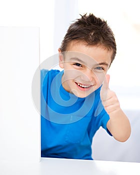 Cute boy is holding blank banner