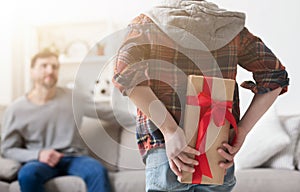 Cute boy holding gift for father behind his back