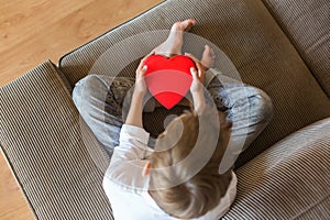 Cute boy holding in hands heart shaped gift box for Valentines day