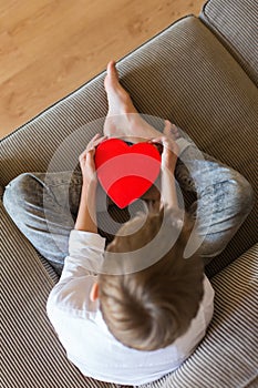 Cute boy holding in hands heart shaped gift box for Valentines day