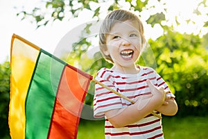 Cute boy holding tricolor Lithuanian flag on Lithuanian Statehood Day, Vilnius, Lithuania