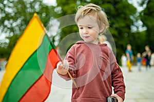Cute boy holding tricolor Lithuanian flag on Lithuanian Statehood Day, Vilnius, Lithuania