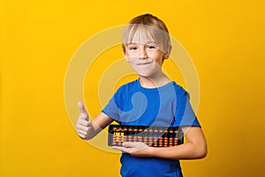 Cute boy holds abacus. Kid study at mental arithmetic school