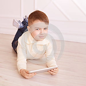 Cute boy. Computer tablet. play game, chat. Training. light interior