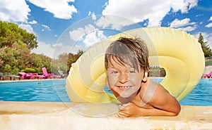 Cute boy with inflatable swim ring in the pool