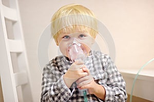 Cute boy inhalation therapy by the mask of inhaler