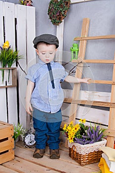 Cute boy in jeans suit and a cap on his head