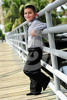 Cute Boy leanings against pole on bridge