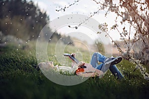 Cute boy lies on the grass with a guitar on sunset