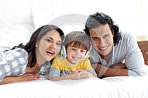 Cute boy listening to music with his parents