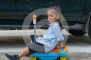 .A cute boy with long hair rides a scooter He had a mischievous glint in his eye.