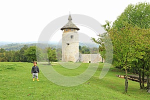 Cute boy on meadow in front of old town Dreznik