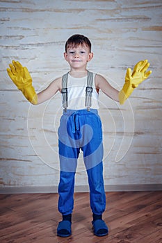 Cute boy in oversized rubber gloves