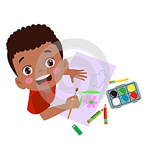 Cute boy painting with watercolors and colored pencils