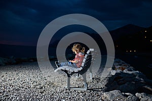 Cute boy with phone on beach