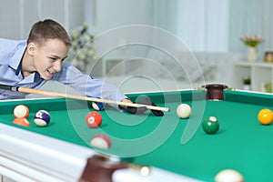 Cute boy playing billiard