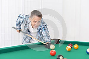 Cute boy playing billiard