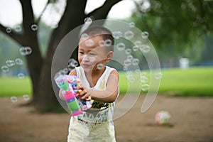 Cute boy playing bubbles gun