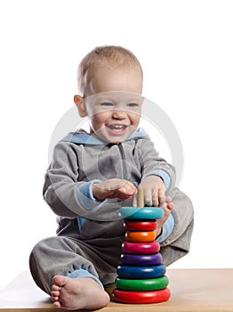 cute boy playing with color pyramid toy