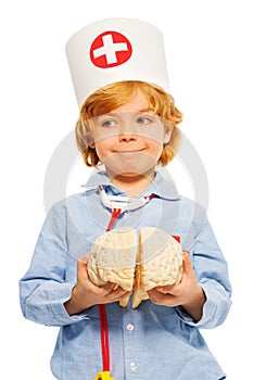 Cute boy playing doctor with toy human cerebrum