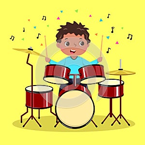 Cute boy playing the drum on yellow background