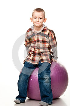 Cute boy playing with fit ball
