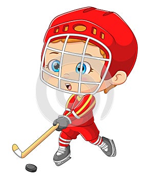 The cute boy is playing a hockey with a stick and wearing safety helmet