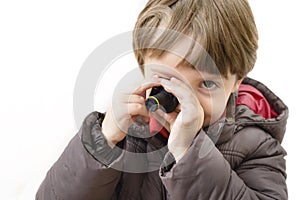 Cute boy playing with miniature camera