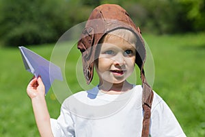 Cute boy playing with paper plane