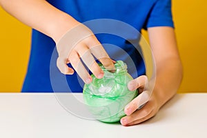 Cute boy playing with popular slime. Little kid opened jar with slime. Child doing experiment scientific method