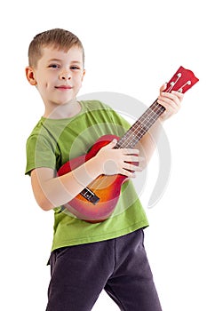 Cute boy playing the ukulele guitar