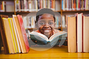 Cute boy reading book in library