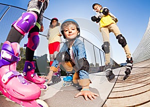 Cute boy in roller skates having fun with friends