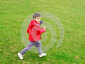 Carino ragazzo correre sul prato verde 