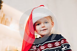 Cute boy in Santa hat and winter sweater.