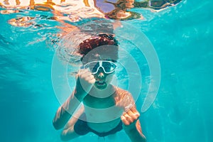 Cute boy in scuba mask swim and pose underwater