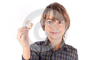 Cute boy showing a hearing aid. Isolated on white background