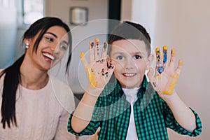 Cute boy showing his hands painted in bright colors