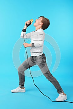 Cute boy singing in microphone on background