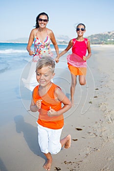 Cute boy with sister and mother on the beach