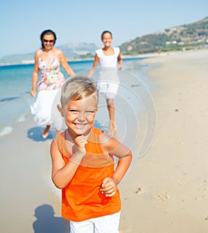 Cute boy with sister and mother on the beach