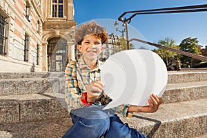 Cute boy sitting on the steps with speech bubble