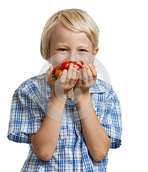Cute boy smelling a bunch of tomatoes