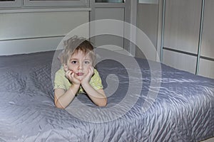 A cute boy in a striped T-shirt. Portrait of a blond boy in a natural setting. The face expresses natural emotions