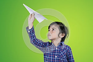 Cute boy throwing a paper plane