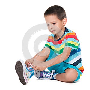 Cute boy tying shoelaces photo